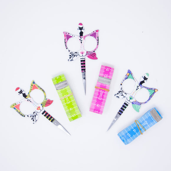 small scissors with handles shaped like cat faces with color matching tape measures